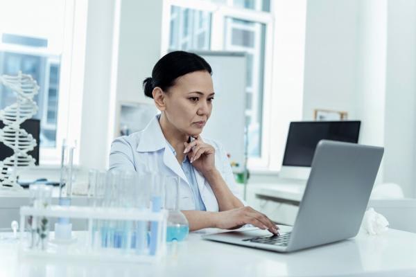 Researcher in lab sourcing samples using laptop